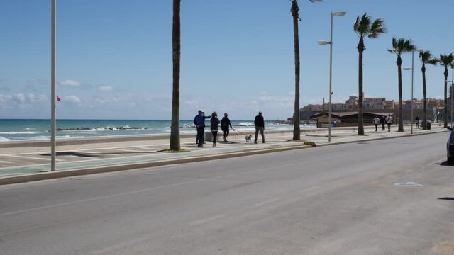 Termoli - Molise  - Tourists stroll along the Cristoforo Colombo promenade in Termoli on a windy day.