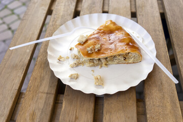 Fish pie with disposable dishes on a wooden table.