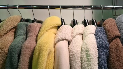 Faux fur coats. Women's winter fur coats hang in a row on hangers