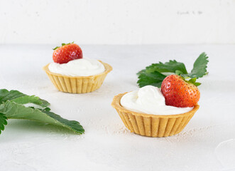 Cottage cheese dessert with strawberries in tartlets on a white table