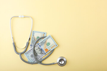 Medical stethoscope and money on a colored background top view close-up