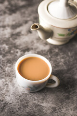 Indian chai in glass cups with metal kettle and other masalas to make the tea.