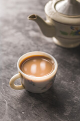 Indian chai in glass cups with metal kettle and other masalas to make the tea.