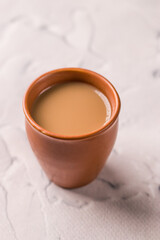 Indian chai in glass cups with metal kettle and other masalas to make the tea.