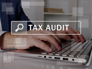  TAX AUDIT text in search bar. Loan officer looking for something at laptop. TAX AUDIT concept.