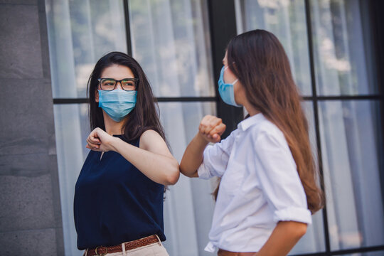 female colleagues keeping social distance, greeting each other by bumping elbows instead. preventing covid 19 coronavirus infection spread. New novel greeting to avoid the spread of coronavirus