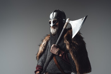 Side view studio shot of old man viking with axe