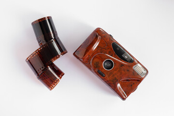 rolled film and film retro camera of red color on a white isolated background. the analog...