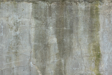 Fragment of an old gray concrete wall. Cracks and wet streaks are present. Background. Texture.