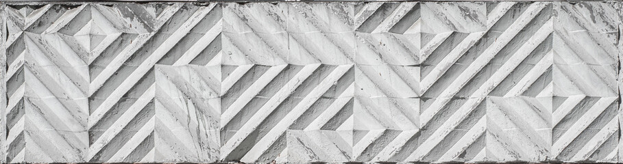 Textured shabby decorative concrete slab wall with diamond-shaped patterns.