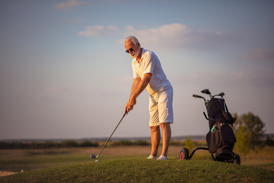 Senior man playing golf alone.