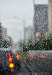 車のフロントガラスから見た雨の日の通勤の車の列の風景