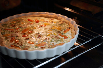 Quiche lauren in the oven in a baking dish
