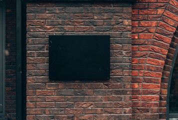 Place for an advertising sign on the background of a beautiful brick wall. Space for the logo. Mockup. It's snowing.A sign at the front of the group.