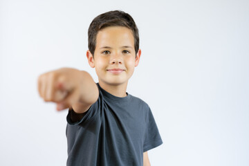 Boy standing and pointing on you over white background