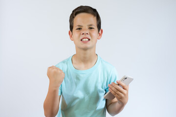 Image of young emotional excited screaming young boy isolated over white wall background play games...