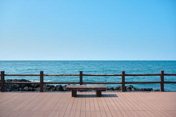 A wooden deck and bench overlooking the vast ocean horizon.