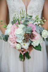 Beautiful delicate wedding bouquet in the hands of the bride