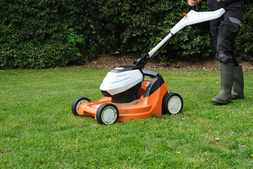 gardener mowing the lawn with a lawn mower