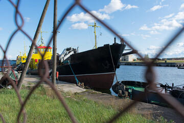 Ship in port behind metal grid fence