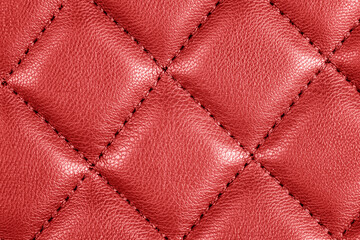 Modern luxury car red leather interior. Part of perforated leather car seat details. Red perforated leather texture background. Texture, artificial leather with diagonal stitching. Leather seats