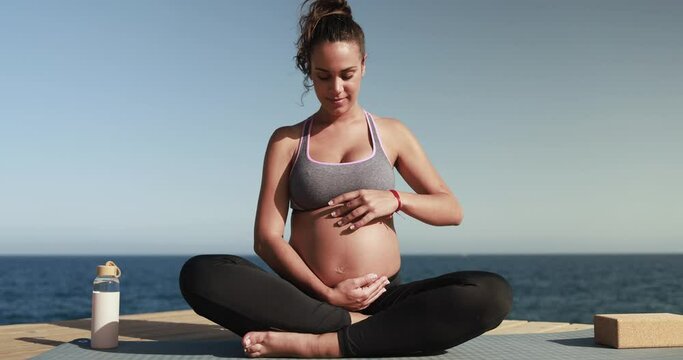Young pregnant woman doing yoga outdoor - Meditation and maternity concept for an healthy lifestyle