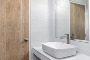 basin and mirror in small bathroom, On white ceramic wall, concept of health and clean environment
