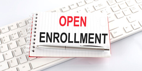 text OPEN ENROLLMENT on keyboard on the white background