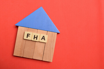 Toy house and alphabet letters with text FHA stands for Federal Housing Administration.
