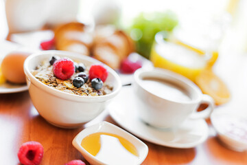 Obraz na płótnie Canvas Breakfast served with coffee, orange juice, croissants, cereals