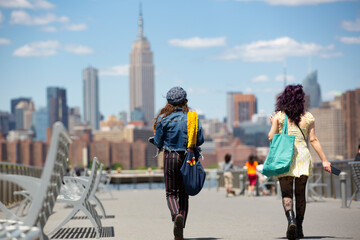 two women walking on Williamsburg's waterfront in Brooklyn - obrazy, fototapety, plakaty