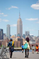 Obraz premium two women walking on Williamsburg's waterfront in Brooklyn