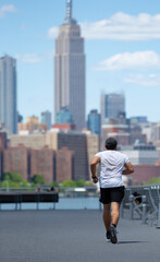 Naklejka premium young man running on Williamsburg's waterfront in Brooklyn