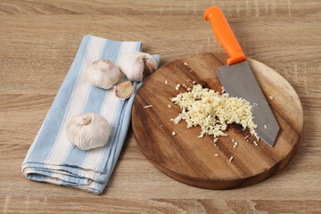 Chopped garlic in wooden tray on table