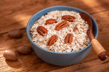 Bowl with oatmeal flakes and pecan nuts