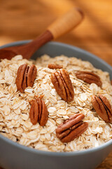 Bowl with oatmeal flakes and pecan nuts