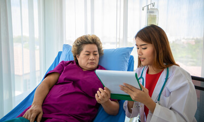 Fototapeta premium Doctor explaining medication to old woman patient at Hospitals