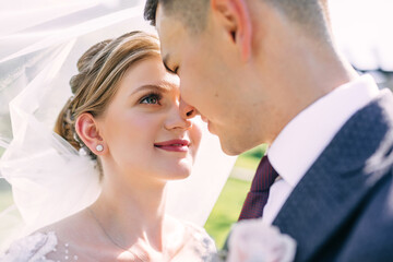 close-up of the newlyweds, the enamored look of the bride looks at the groom on the wedding day
