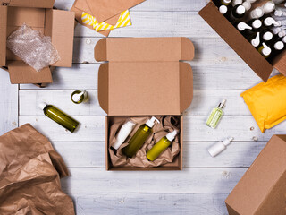 Cardboard box with cosmetic bottles on wooden background