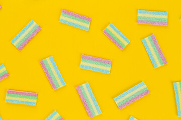 Colorful gummy candy pattern on an yellow background. Soft gums look from above. Variation concept. Gay colors. Sweet food dessert.