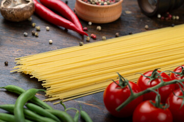 Spaghetti and Ingredients on an old and vintage wooden table. Italian Cuisine.