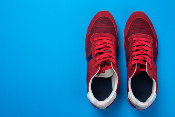 Pair of stylish red sneakers on color background, space for text.
