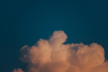 Close up shot of orange colored fluffy sunset clouds in sky