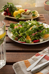 Summer sunny meal with big plate of salad with greens, reddish, eggs, olives. Keto diet concept. Low carb diet. 