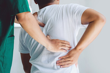 Male doctor therapist doing healing treatment on man's back.Back pain patient, treatment, medical...