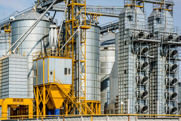 Modern Granary elevator. Silver silos on agro-processing and manufacturing plant for processing drying cleaning and storage of agricultural products, flour, cereals and grain. seed cleaning line