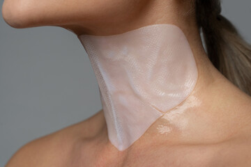 Woman with a sheet mask applied on her neck