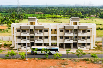 Top view of an Indian colony with bitumen road , building looking in line with pattern, small parking, playground looking awesome from top of a building. - 435057949