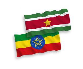 Obraz premium National vector fabric wave flags of Republic of Suriname and Ethiopia isolated on white background. 1 to 2 proportion.