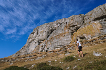 Boy walking in the mountain with a stick